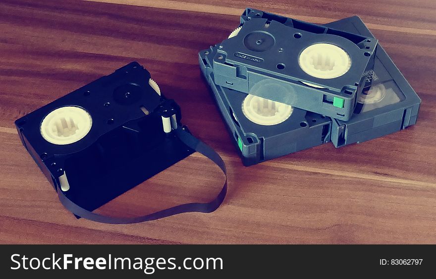 Betamax Tapes on Top of Brown Wooden Surface