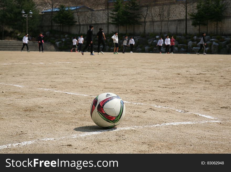 White Red And Green Ball Near Group Of People Playing Soccer