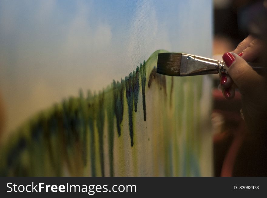 Woman With Red Nails Painting Green Stripe on Canvas