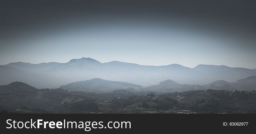 Greyscale Photo of Mountains With Mist