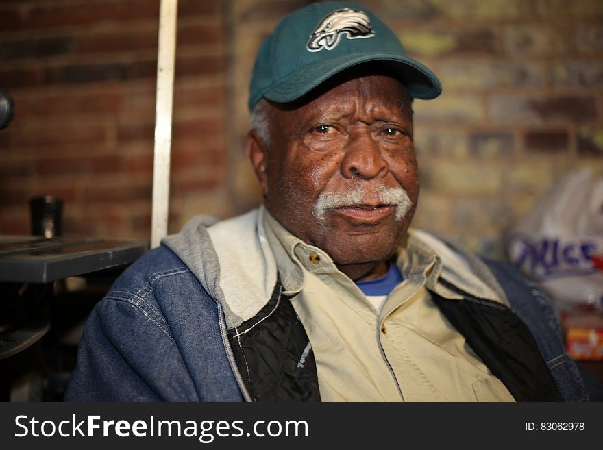 Portrait of senior man in jean jacket wearing Philadelphia Eagles hat. Portrait of senior man in jean jacket wearing Philadelphia Eagles hat.