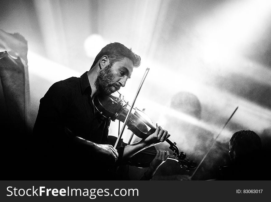 Man on stage playing violin in concert in black and white. Man on stage playing violin in concert in black and white.