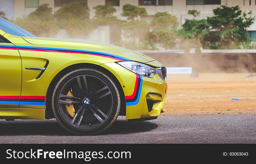 Front of BMW M4 car on road on sunny day.