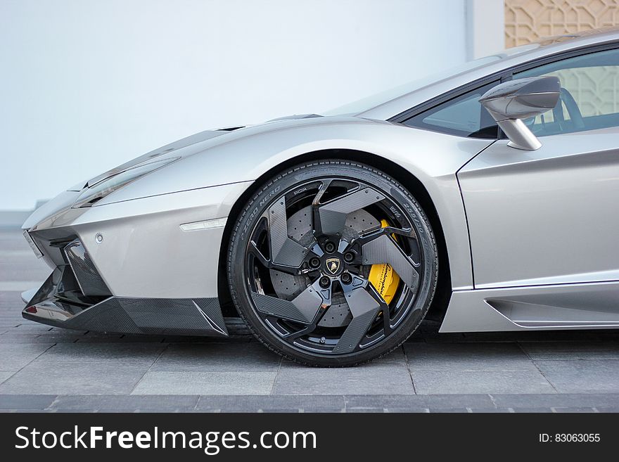 Close up of silver Aventador Lamborghini sports car on driveway.