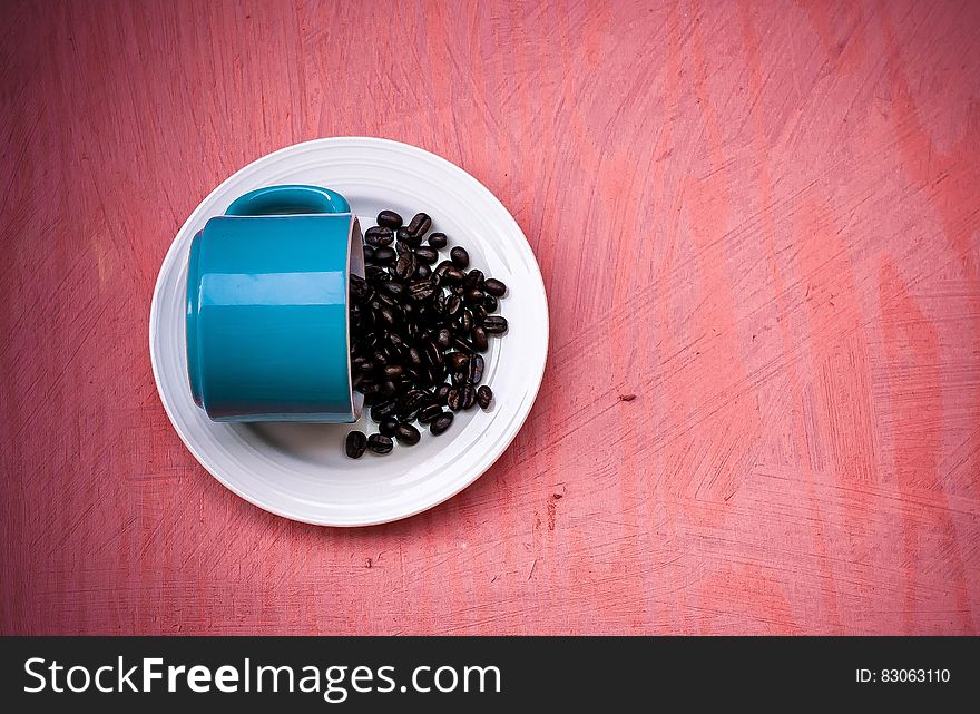 Blue Ceramic Tea Cup With Beans on Plate