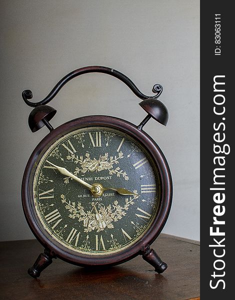 Brown Framed Alarm Clock on Brown Table