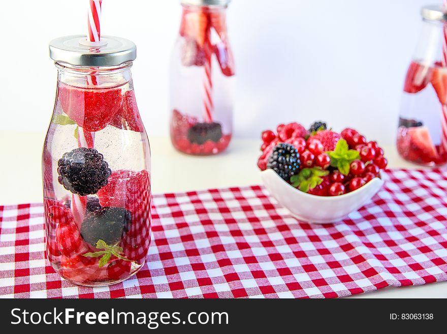 Red Cherry and Grapes on Clear Glass Bottle