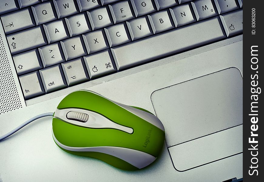 Green Mouse on silver Laptop