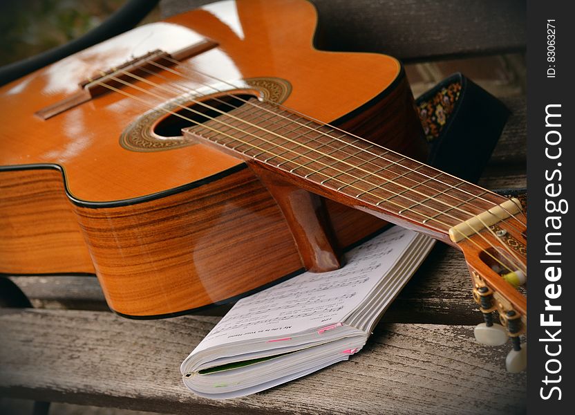 Brown Acoustic Guitar on White Music Note Book