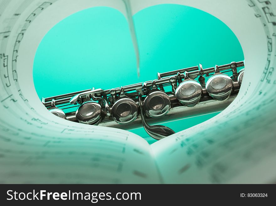 Music Note Book And Silver Soprano Flute Close Up Photography