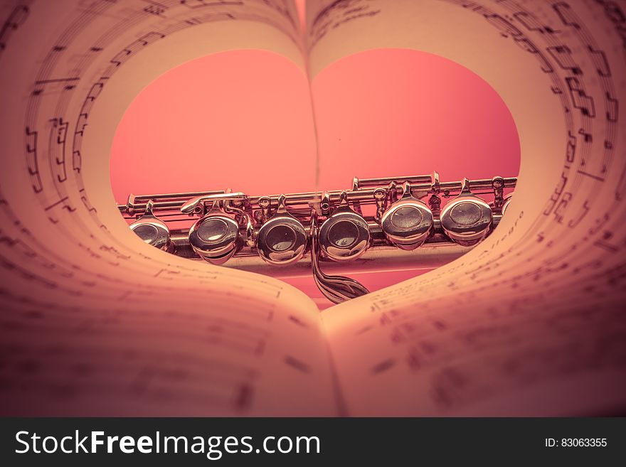 Chrome Musical Instrument Viewed on Heart Shaped Music Score Book