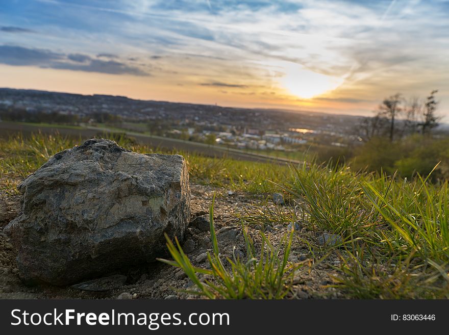 Gray Stone on Grassy Field during Under Cloudy Sky during Sunset