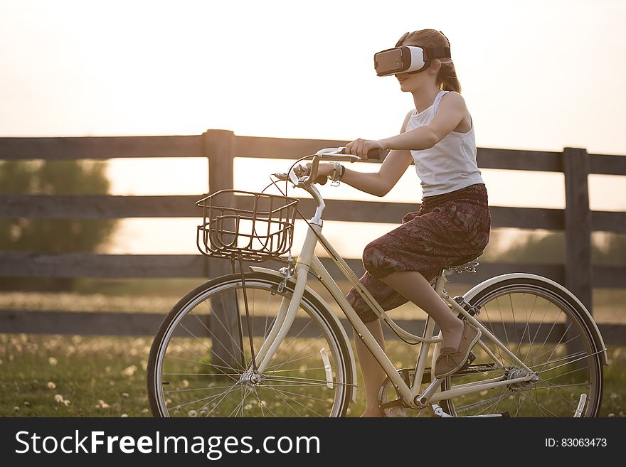 Girl Wearing Vr Box Driving Bicycle during Golden Hour