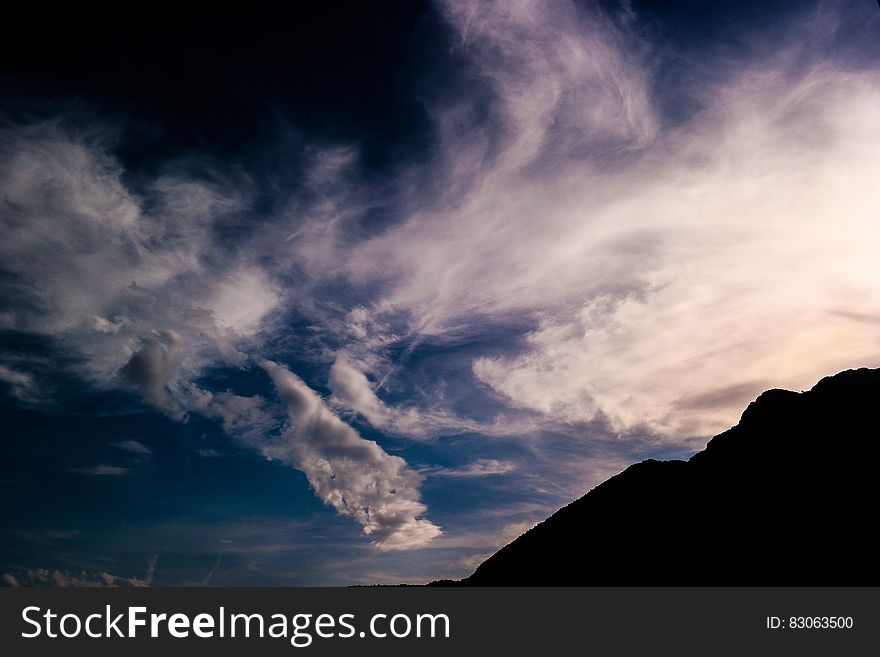 Silhouette of Mountain Under White Clouds