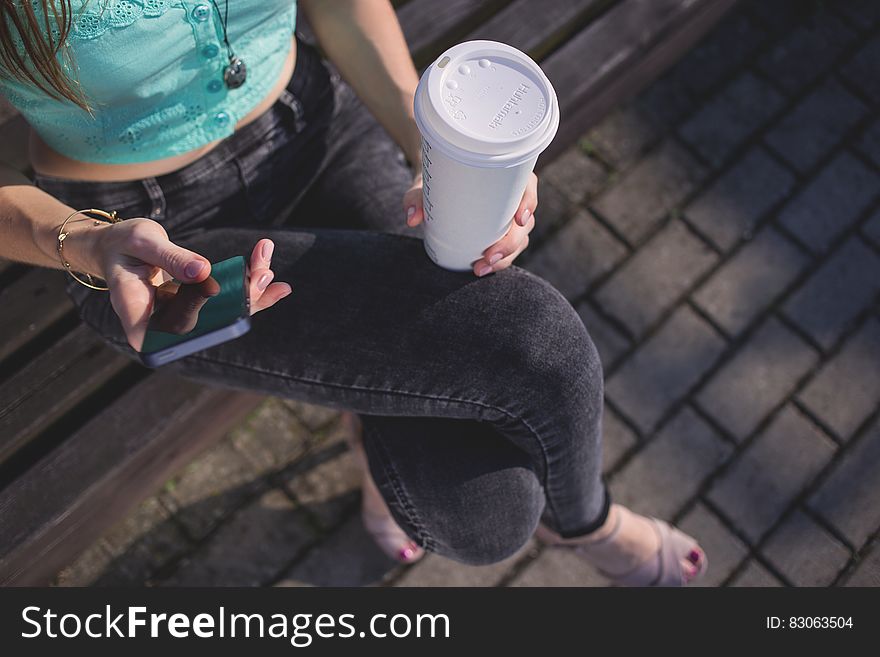 Woman Holding White Disposable Cup and Smartphone