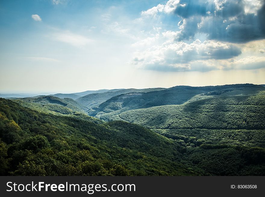 Green Tree Coated Mountain Under White and Blue Cloudy Sky at Daytime