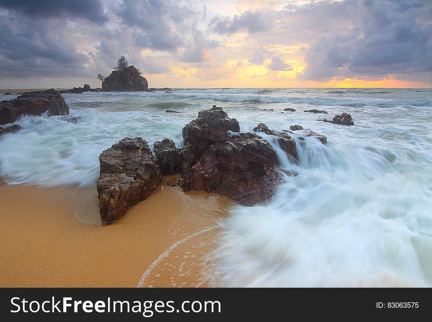 Rock on Beach Shore With Waves Crashing during Cloudy Daytime Sky