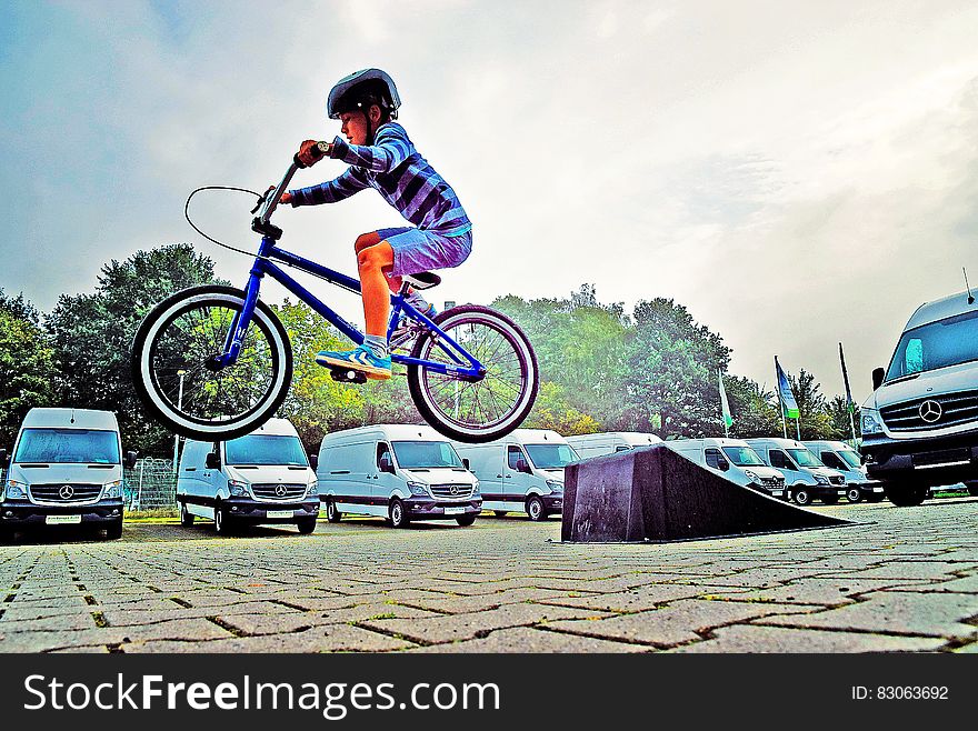 Boy in Black Nutshell Helmet on Blue Bmx Bike Having Hangtime After Taking Off on Ramp