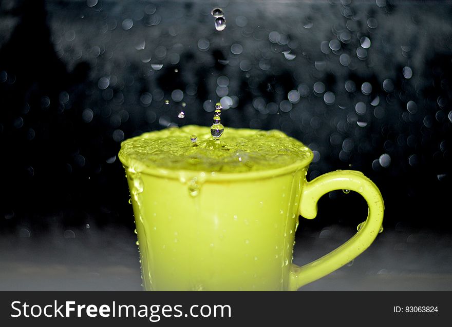 Yellow Ceramic Mug With Water Droplets in Time Lapse Photography