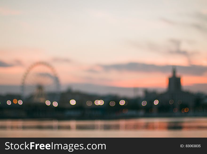 Blur of amusement park on horizon at sunset reflecting in waterfront. Blur of amusement park on horizon at sunset reflecting in waterfront.