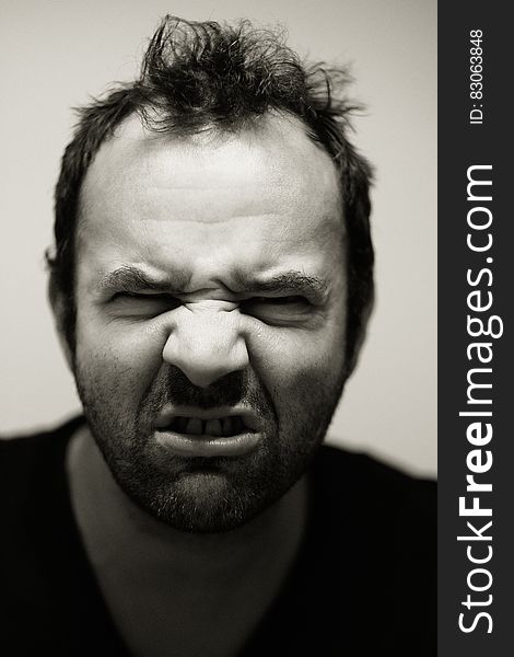 Black and white portrait of angry man grimacing.