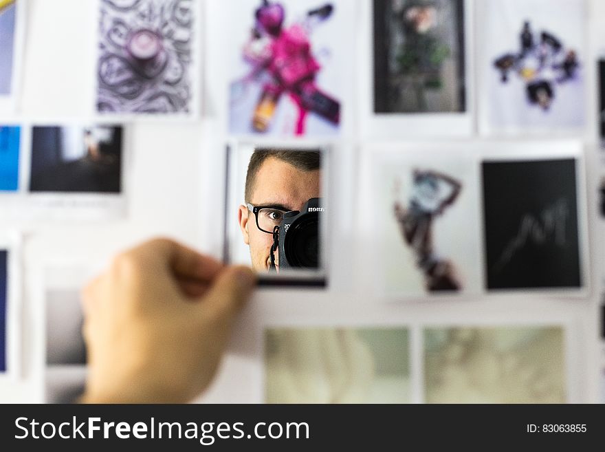 Hand of photographer putting selfie in collage of pictures on wall. Hand of photographer putting selfie in collage of pictures on wall.