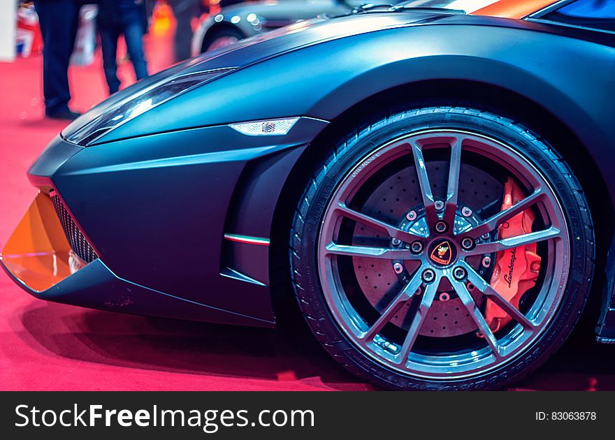 Close up of tire and front of blue Lamborghini sports car inside showroom. Close up of tire and front of blue Lamborghini sports car inside showroom.