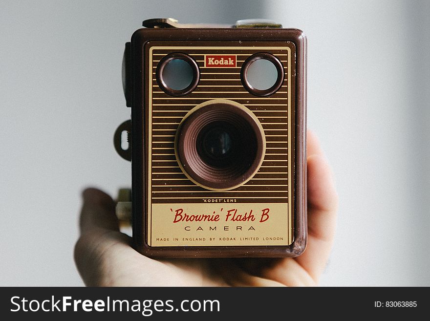 Hand holding vintage Kodak Brownie analog film camera. Hand holding vintage Kodak Brownie analog film camera.
