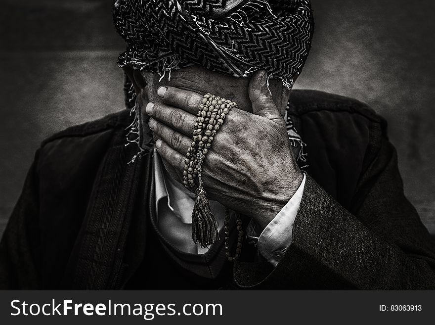 An old man with a turban hiding his face. An old man with a turban hiding his face.