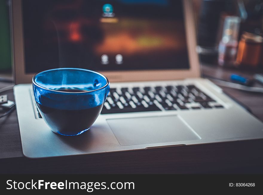 Blue Glass Cup On Silver Laptop Computer