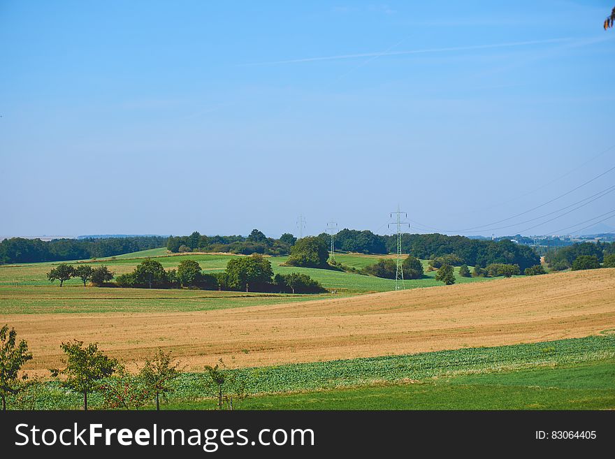 Brown Sand Dunes Surrounded By Green Grass Under The Blue Sky