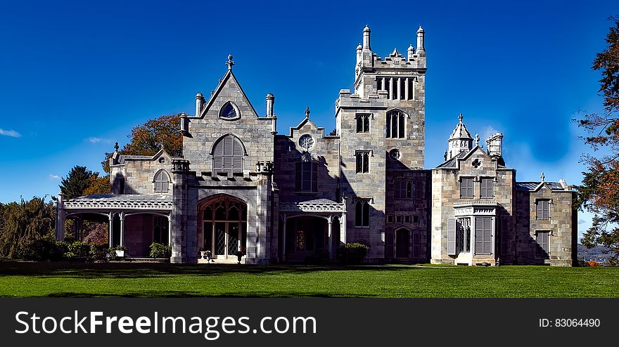 Exterior of mansion on green lawn against blue skies on sunny day in New York, USA. Exterior of mansion on green lawn against blue skies on sunny day in New York, USA.