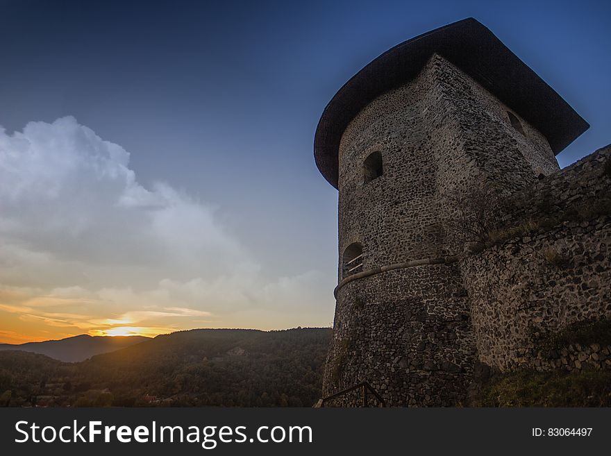 Photograph Of Brown Temple Near Mountains During Sunset