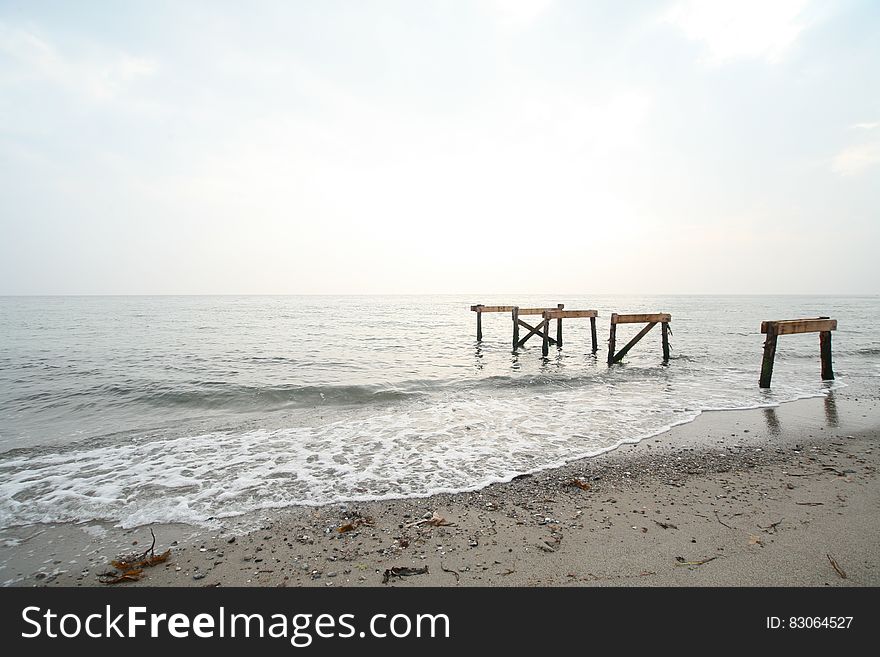 Wooden piles on sandy coastline on sunny day. Wooden piles on sandy coastline on sunny day.