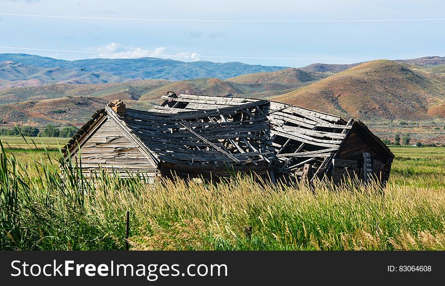 Brown Wooden House on Field Near Mountain during Daytime
