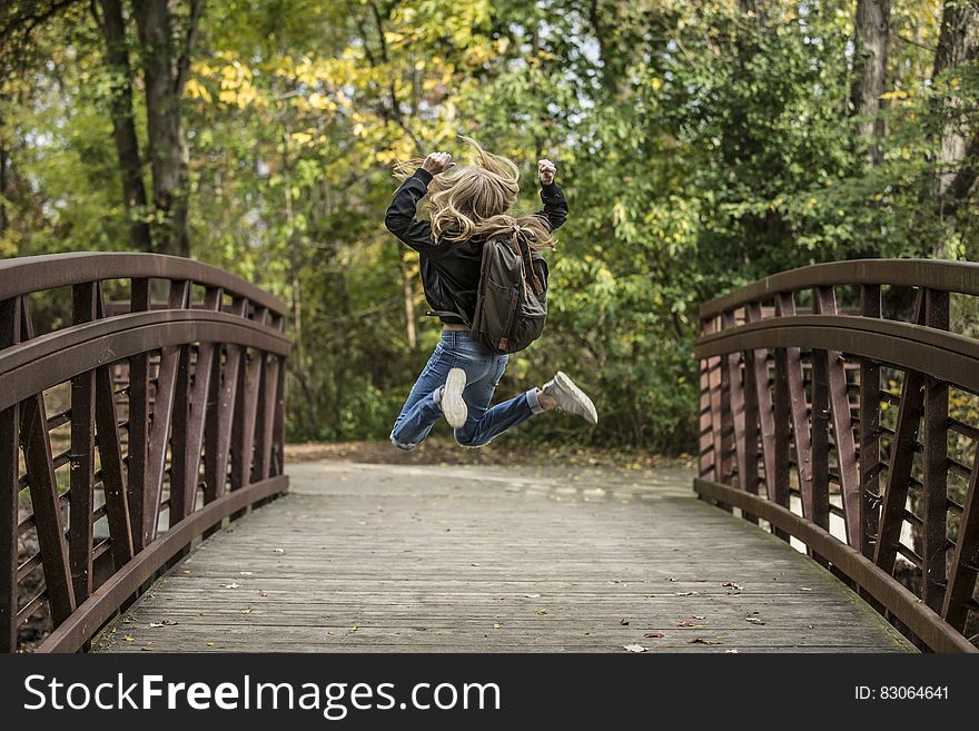 Girl Jumping on the Bridge Wearing Black Jacket