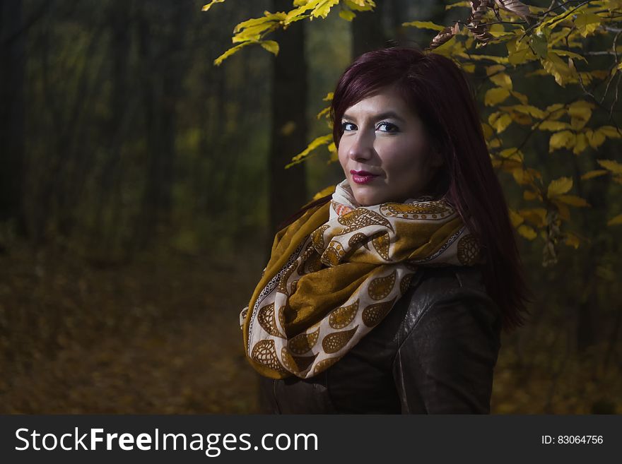 Woman Wearing Brown and White Scarf Surrounded by Trees at Daytime