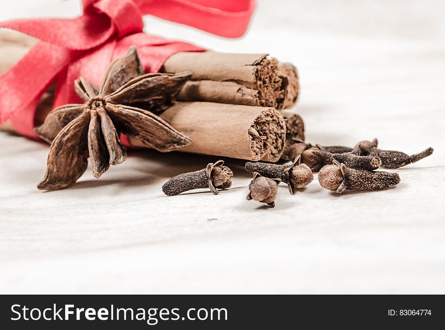 Cinnamon, star anise and cloves wrapped in red ribbon. Cinnamon, star anise and cloves wrapped in red ribbon.