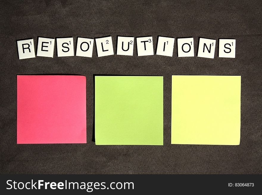 Resolutions spelled with Scrabble tiles with colorful post it notes.