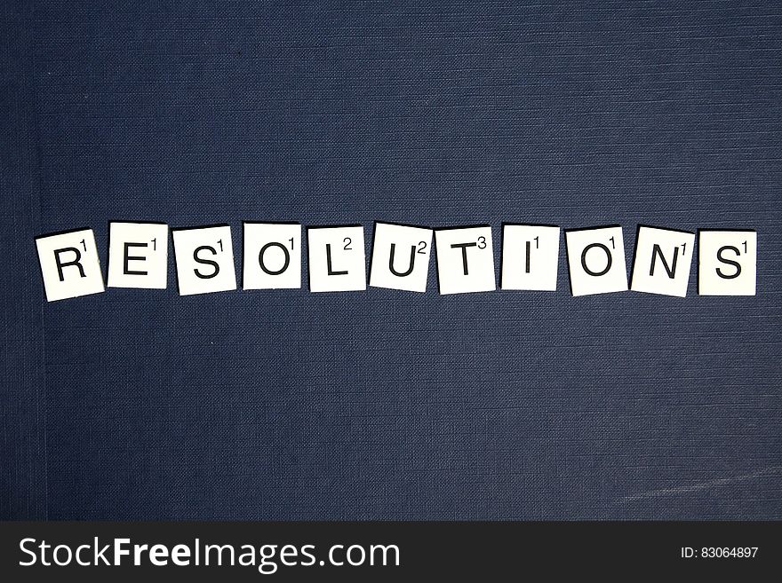 Resolutions spelled in Scrabble tiles on black.
