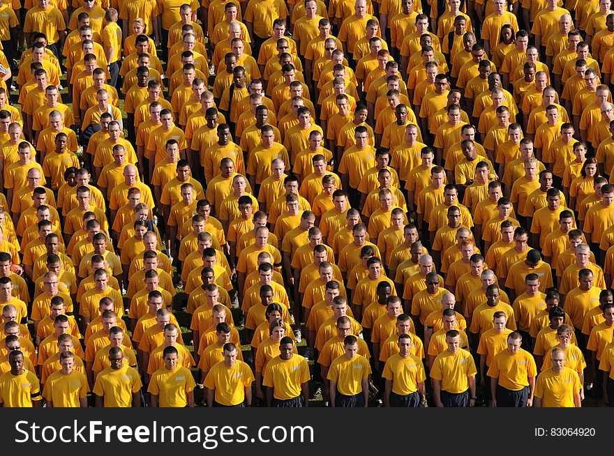 Navy personnel standing in formation in yellow shirts. Navy personnel standing in formation in yellow shirts.