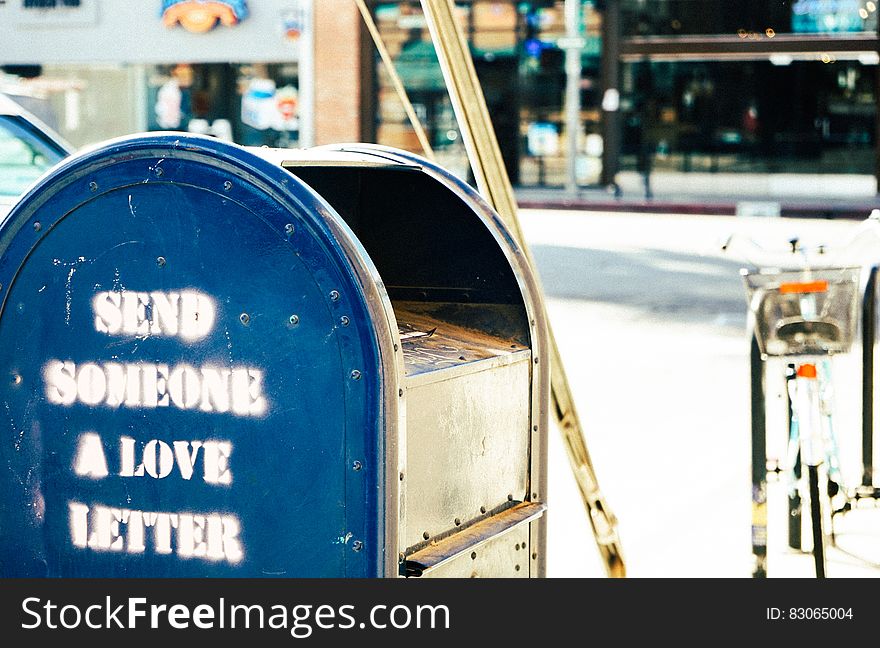 Blue mailbox with graphics send someone a love letter on city streets.