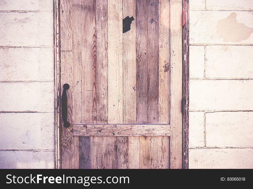 Close up of rustic wooden door on cement block wall.