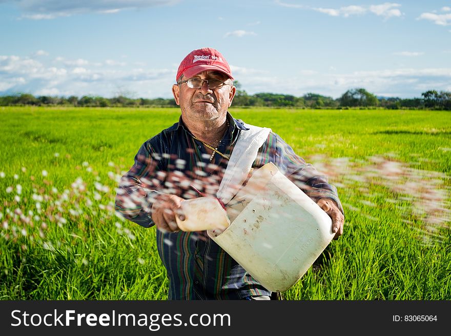 Man In Red Fitted Cap In Green High Grass During Daytime