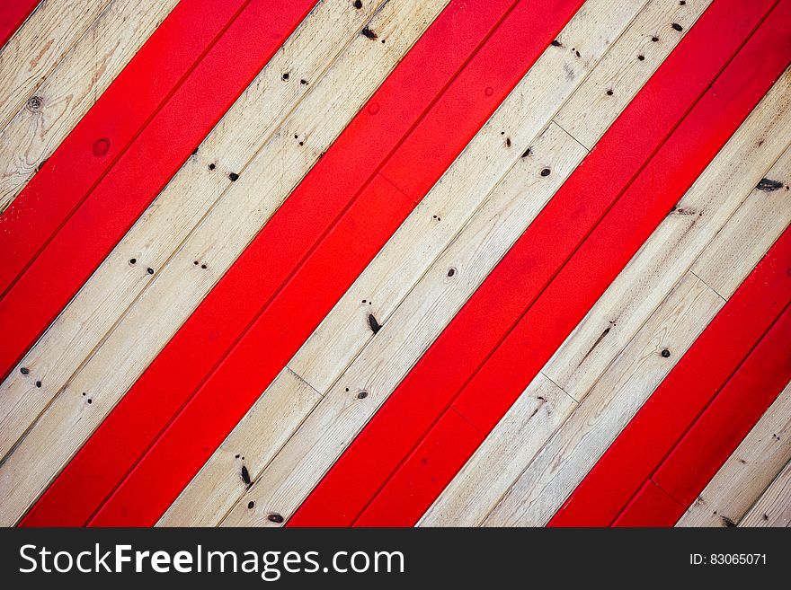 Abstract pattern of red and white boards in geometric stripes.