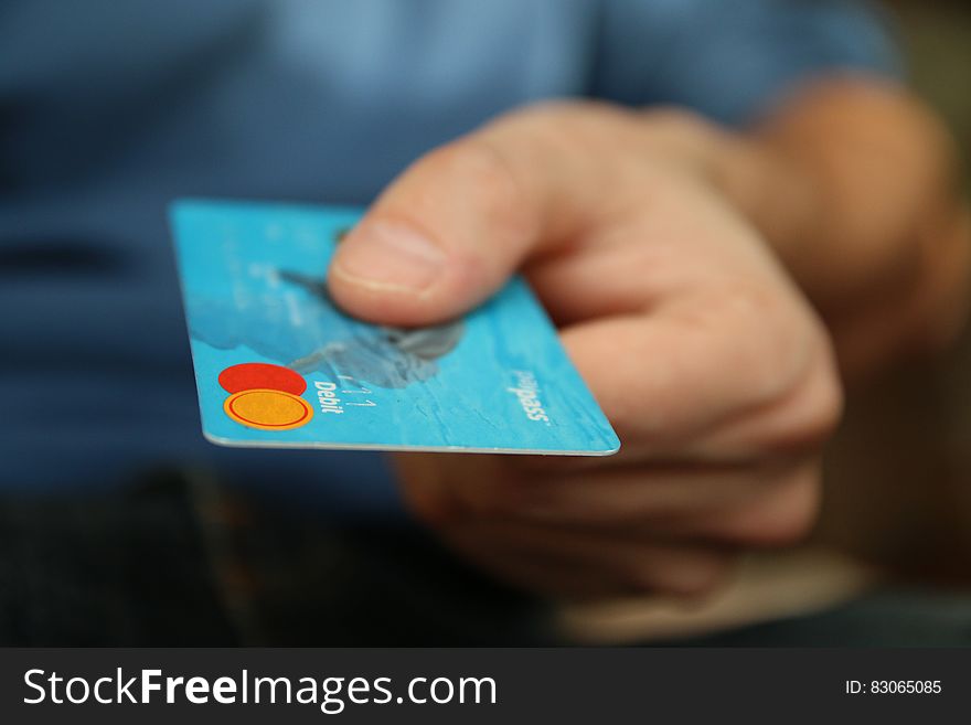 Close up of hand holding blue credit card. Close up of hand holding blue credit card.