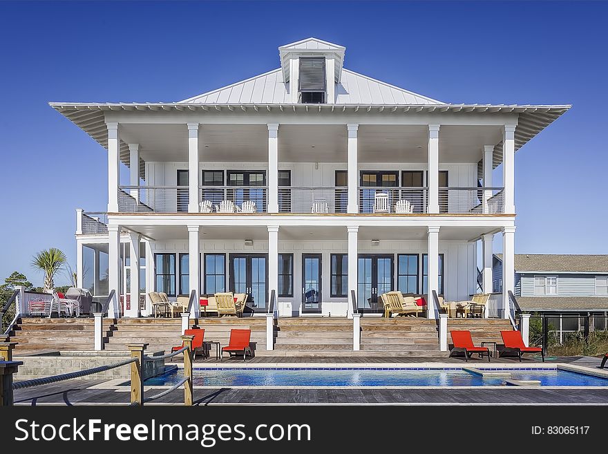 Exterior of luxury home with swimming pool on sunny day. Exterior of luxury home with swimming pool on sunny day.