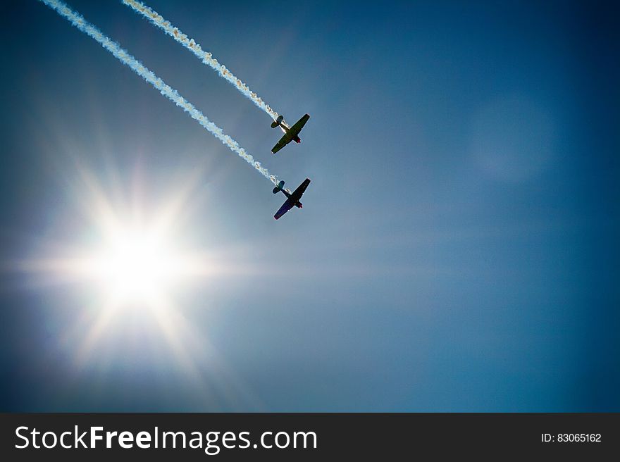Two Airplane Flying Under Blue Sky Emitting White Smoke
