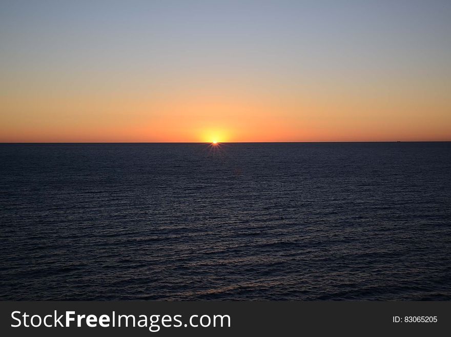Sunset in the open sea and colored sky above the horizon. Sunset in the open sea and colored sky above the horizon.