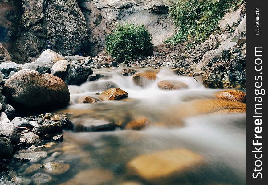 Water flowing over stones in creek with long exposure blur effect.